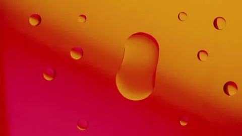 Two drops connect together on a red and yellow gradient background. Видео 303059406