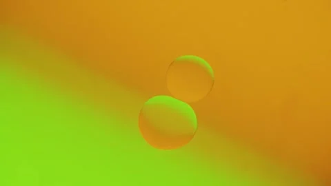 Two drops connect on a yellow-green gradient background. Vídeo Stock 303058936