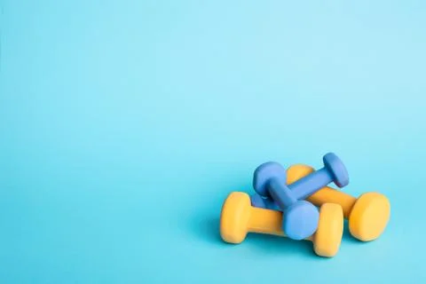 Two dumbbells on blue background. Stock Photos