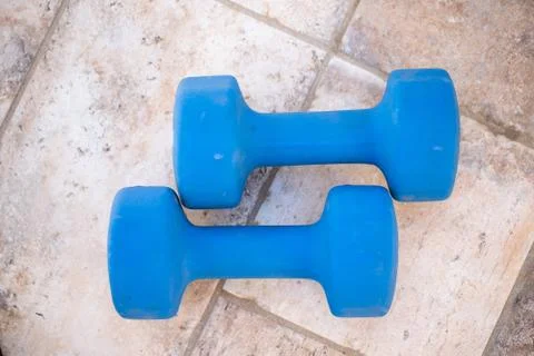 Two dumbbells isolated high angle view.Pair of blue dumbbell weights on wood Stock Photos