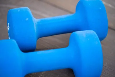 Two dumbbells isolated high angle view.Pair of blue dumbbell weights on wood Stock Photos