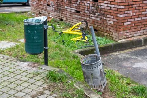 Two dumpsters of garbage and yellow bycicle Stock Photos
