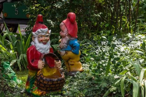 Two dwarfs between plants in a mini golf course from a amusement park Stock Photos