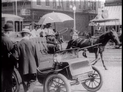 Two early 1910s era men drive a car from the city to a suburban home. Stock Footage 75289824