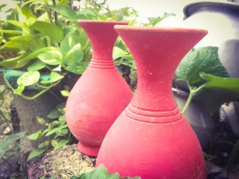 Two earthen pots placed side by side in a garden. Stock Photos