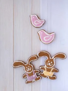 Two Easter Bunny and two pink birds cookies on the white wooden background Stock Photos