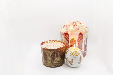Two Easter cakes and a candle on a white background Stock Photos
