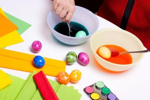 Two easter eggs in bowls of colored water Fotos Stock