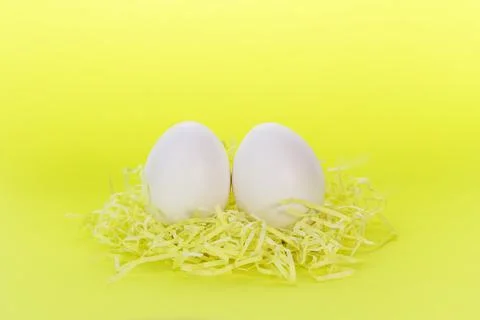 Two Easter eggs on a yellow background.Funny eggs. Postcard with space for te Stock Photos