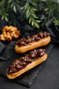 Two eclairs with dark chocolate on black board Stock Photos