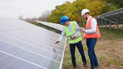 Two ecological engineers at the solar panels park controlling the photovoltaic Stock Footage 164548608