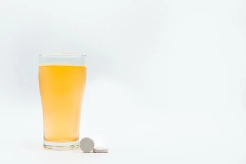 Two effervescent tables on white background and orange effervescent bubbles o 库存照片