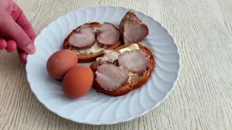 Two Eggs and Meat Topped Bread on White Plate Stock-Footage 329977560