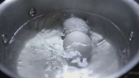 Two eggs are cooked in boiling water close-up Stock Footage 73103935