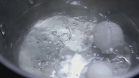 Two eggs are cooked in boiling water close-up Stock Footage 73104582