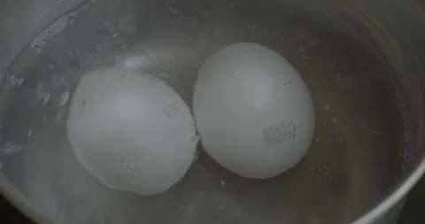 Two Eggs Boiling in Hot Water – Simple Cooking Scene Stock Footage 317013802