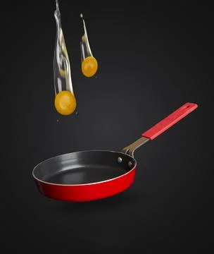 Two eggs falling into the pan - breakfast cooking concept Stock Photos