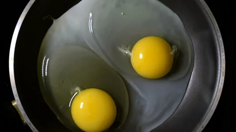 Two eggs fried in a pan. Time lapse. Zoom. The rotation of the camera. Stock Footage 67729781