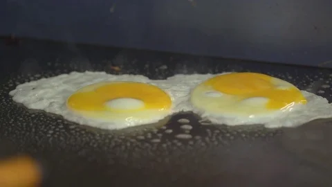 Two eggs frying on a griddle Stock Footage 73882040