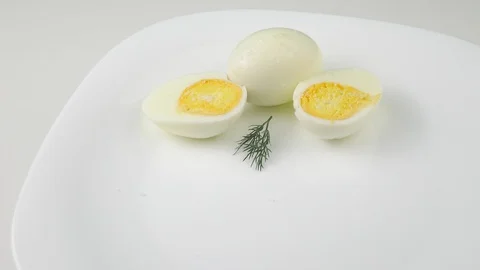 Two eggs. Healthy Breakfast.Cut in half.Rotating on a white plate. Stock-Footage 127687994