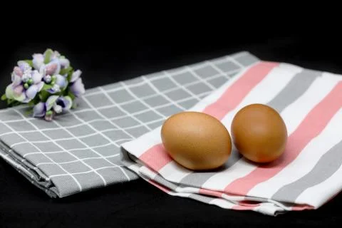Two eggs on a light towel isolated on black background Stock Photos