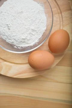 Two eggs on a round stand next to a plate of flour Stock Photos