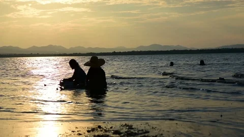 Two elder in the lake like a sea have a mountain sunset in evening Stock Footage 129171527