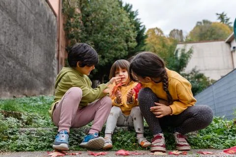 Two elder sisters cleaning the face of younger sister 스톡 사진
