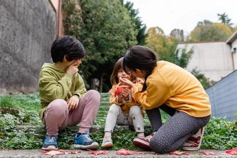 Two elder sisters helping to clean the face of younger sister 스톡 사진