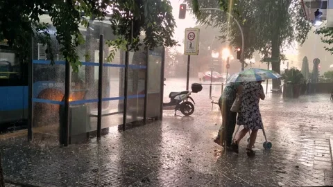 Two elder women trying to scape de rain and hail in the middle of a Storm Stock Footage 155766937