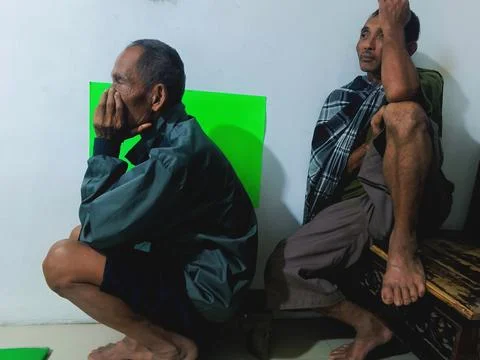 Two elderly Asian men relaxing indoors. Stock Photos