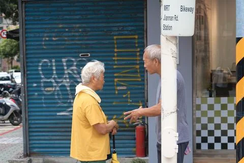 Two Elderly Men Chat by MRT Jiannan Road Station in Taipei Daily Life Stock-Fotos