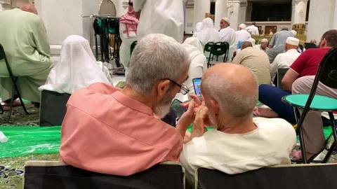 Two elderly men chatting while waiting for prayer time Stock Footage 332593481