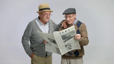 Two elderly men reading a newspaper and talking Video stock 77678283