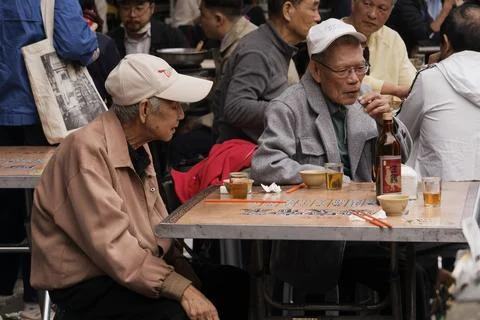 Two Elderly Men Sharing Rice Wine and Chatting at Dadaocheng Outdoor Table Stock-Fotos