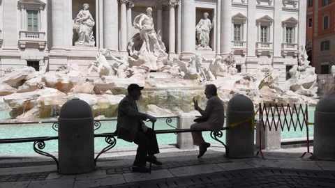 Two elderly people chatting sitting on the balustrade of the trevi fountain Stock Footage 135359425