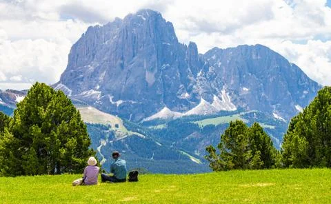 Two elderly people seen at Seceda peak in the background view of the mountain Stock Photos