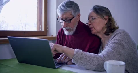 Two elderly people sit in front of the computer and write a letter to relatives Stock Footage 152975259