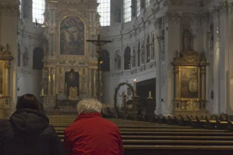 Two elderly people sit at the neogothic-style Church in German Foto stock