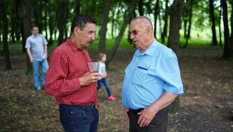 Two elderly people talking in a park. 写真素材