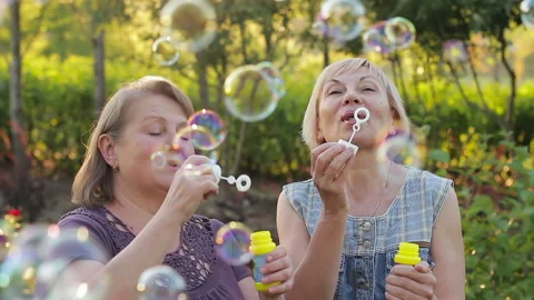 Two elderly women blowing bubbles. Elder... | Stock Video | Pond5