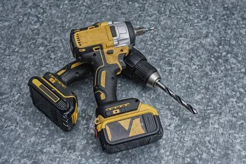 Two electric power tools, a yellow and black cordless drill and an impact d.. Stock Photos