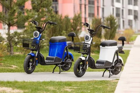 Two electric scooters bikes in the center of city. Electric urban transportation Stock Photos