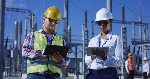Two electrical workers on tablets outside Stock Photos
