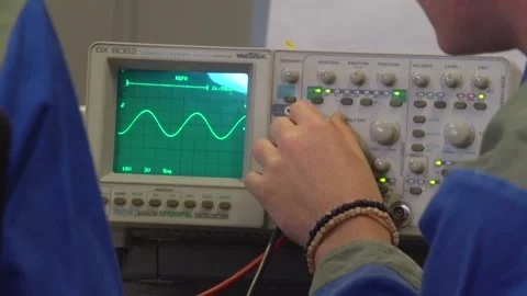 Two electrician apprentices working with oscilloscope Stock Footage 237316007