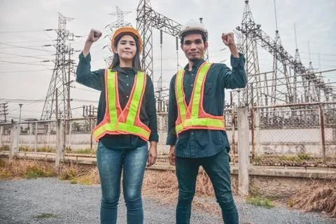 Two Electrician Engineer high voltage tower background Stock Photos
