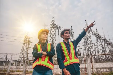 Two Electrician Engineer high voltage tower background Foto stock