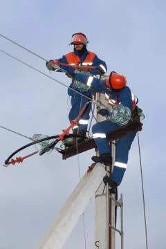 Two electrics working on top of an electricity pylon Stock Photos