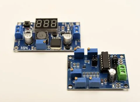 Two electronic devices on a blue printed circuit board. A small electronic .. Foto stock