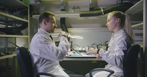 Two electronic engineers putting on protective glasses and start soldering Video stock 112064564